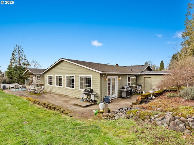 back of property with a patio, a lawn, and french doors