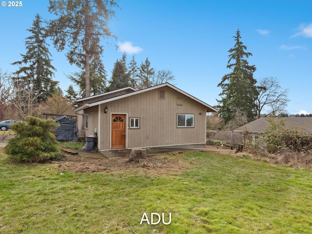 rear view of property featuring a lawn