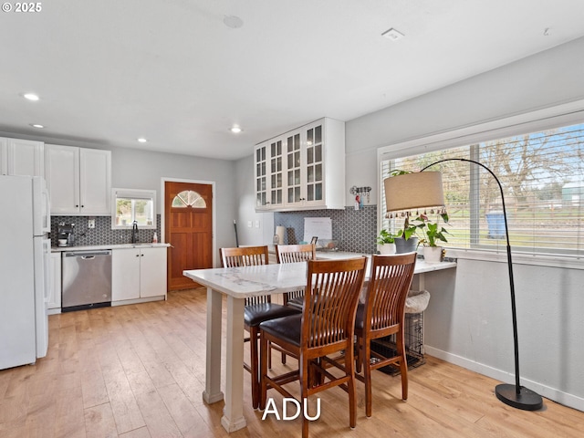 dining room with sink and light hardwood / wood-style flooring