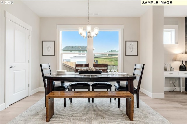 dining area featuring light hardwood / wood-style flooring and a chandelier