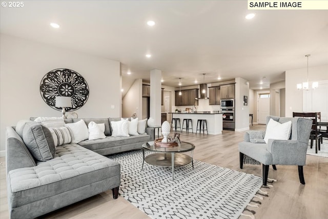 living room featuring an inviting chandelier and light hardwood / wood-style floors