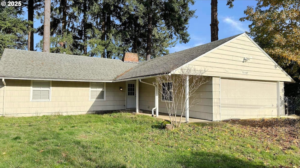 single story home with a garage and a front lawn