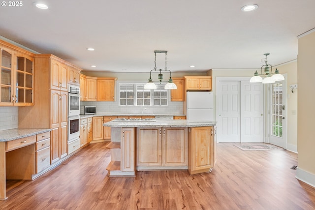 1702 24th Ave, Longview, WA 98632 - kitchen featuring white appliances, a kitchen island, light wood-style flooring, backsplash, and recessed lighting