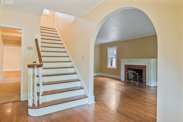 1702 24th Ave, Longview, WA 98632 - stairway featuring arched walkways, wood finished floors, a fireplace, and ornamental molding