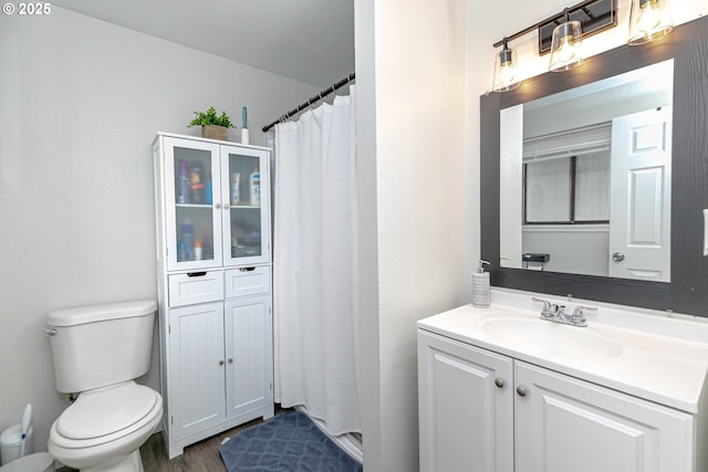 full bathroom featuring vanity, a shower with shower curtain, toilet, and wood finished floors