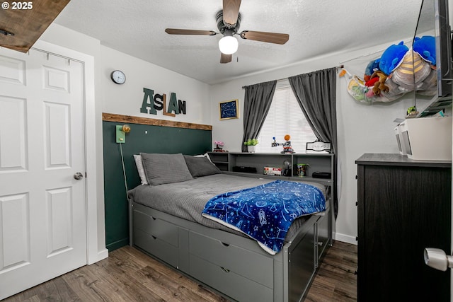 bedroom with baseboards, a textured ceiling, ceiling fan, and wood finished floors