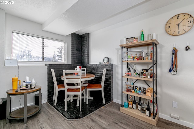 dining space with wood finished floors, baseboards, and a textured ceiling