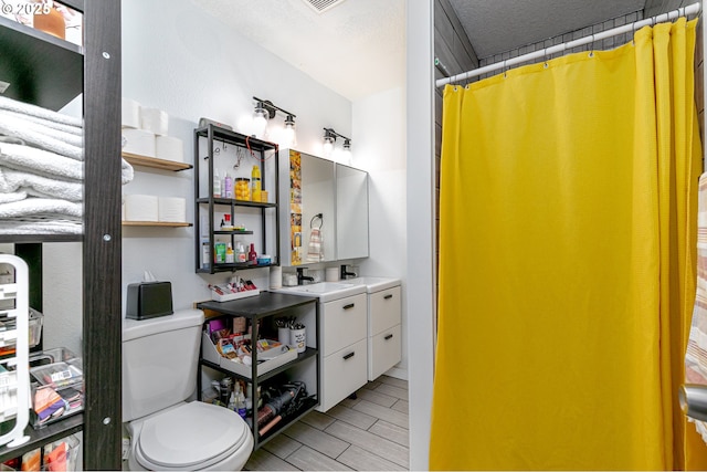 full bathroom with vanity, a shower with curtain, wood finish floors, a textured ceiling, and toilet