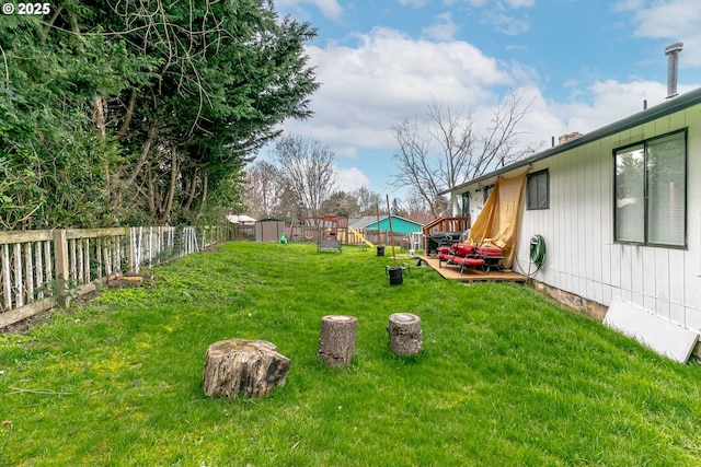 view of yard with an outdoor structure, a fenced backyard, and a shed