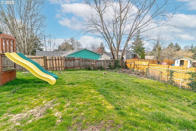 view of yard with a playground and a fenced backyard