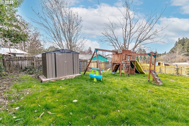 view of yard featuring a fenced backyard, an outdoor structure, a shed, and a playground