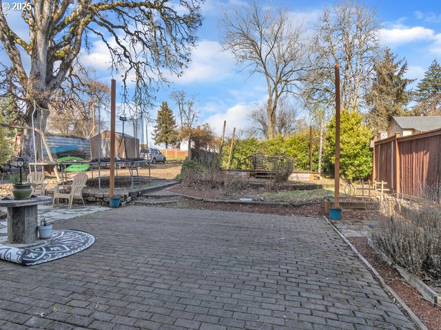 view of patio / terrace with a trampoline and fence