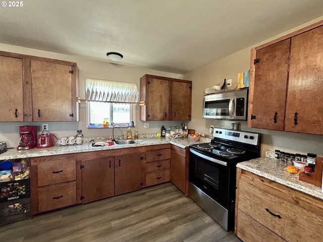 516 W Railroad Ave, Goldendale, WA 98620 - kitchen featuring a sink, stainless steel appliances, brown cabinetry, dark wood finished floors, and light countertops