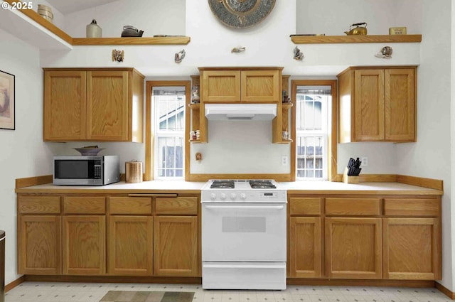 2451 Bowtie Ave, Eugene, OR 97404 - kitchen featuring white range with gas stovetop, stainless steel microwave, plenty of natural light, light countertops, and lofted ceiling