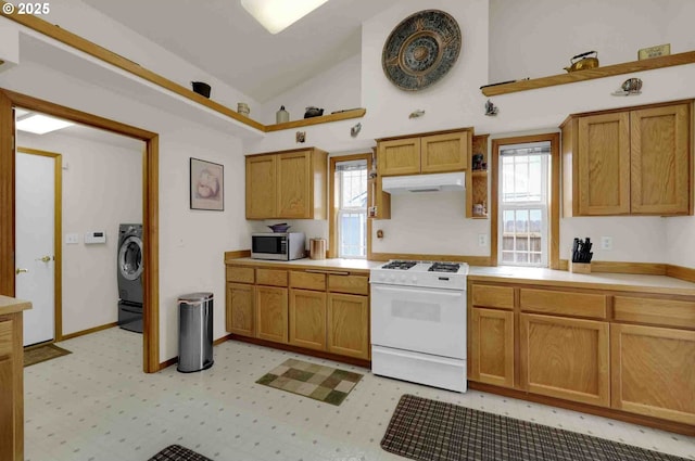 2451 Bowtie Ave, Eugene, OR 97404 - kitchen featuring white gas range oven, stainless steel microwave, lofted ceiling, light countertops, and washer / dryer