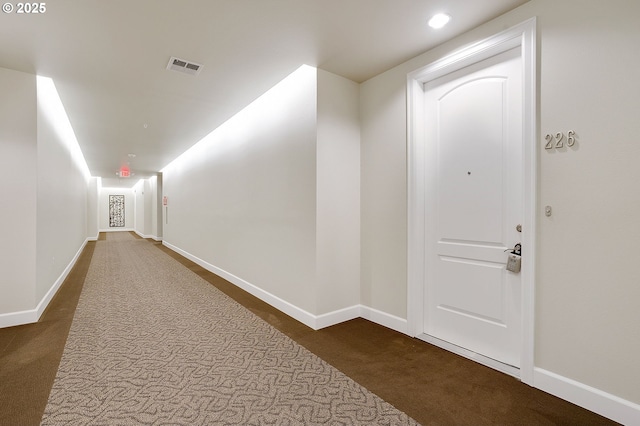 hallway featuring dark colored carpet