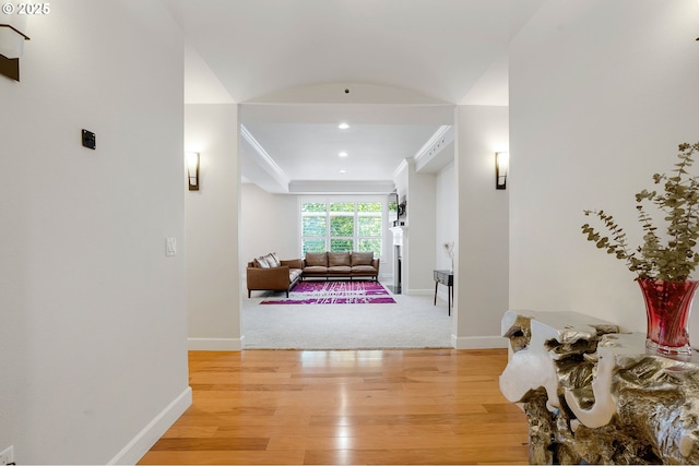 corridor featuring ornamental molding and light hardwood / wood-style flooring