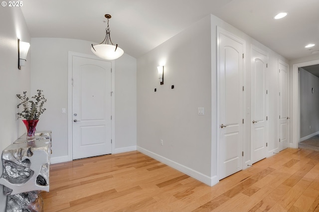 foyer with vaulted ceiling and light wood-type flooring