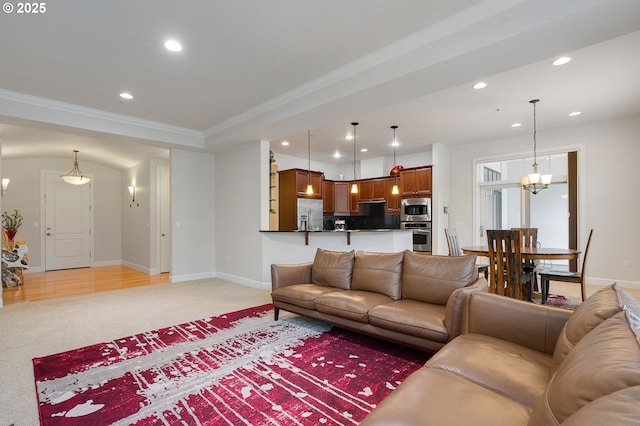 living room featuring crown molding, light colored carpet, and a chandelier