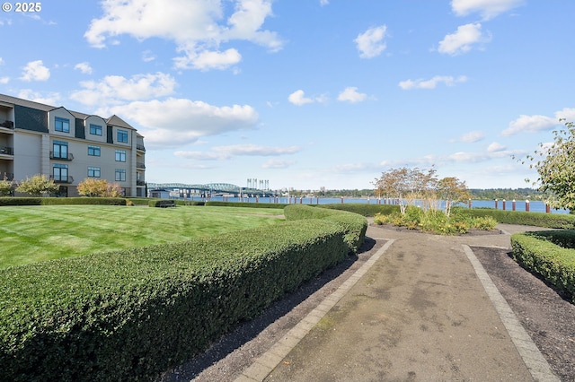 view of property's community featuring a lawn and a water view