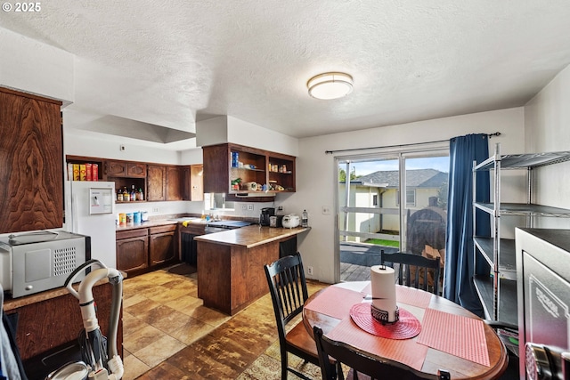 kitchen with open shelves, a textured ceiling, a peninsula, and white refrigerator with ice dispenser