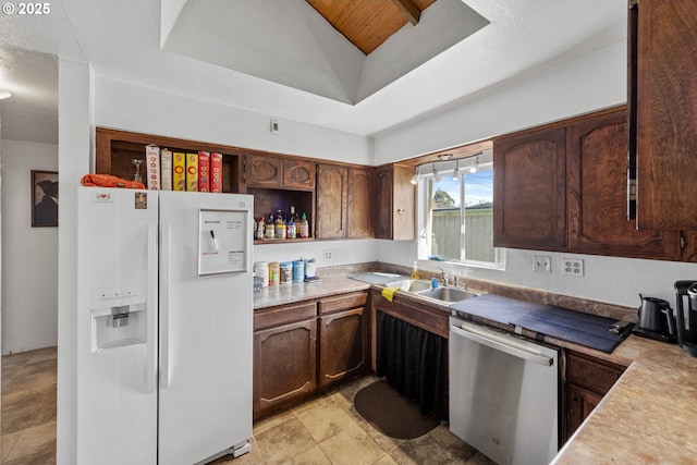 kitchen featuring a sink, a tray ceiling, open shelves, white refrigerator with ice dispenser, and dishwasher