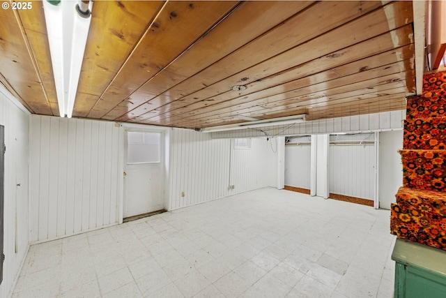 finished basement featuring wood ceiling and light floors