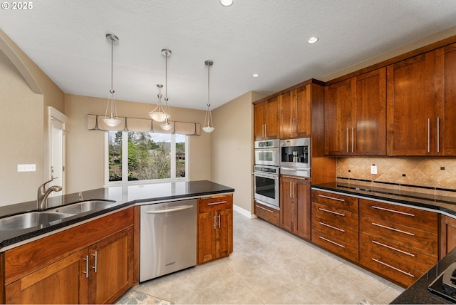205 W Oriole Dr, Roseburg, OR 97471 - kitchen featuring brown cabinetry, appliances with stainless steel finishes, a sink, hanging light fixtures, and backsplash