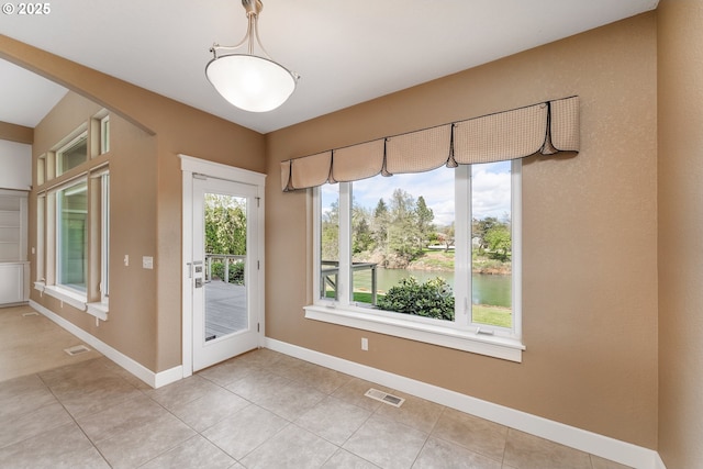 205 W Oriole Dr, Roseburg, OR 97471 - interior space featuring light tile patterned floors, arched walkways, visible vents, a water view, and baseboards