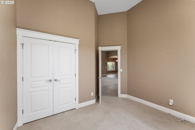 205 W Oriole Dr, Roseburg, OR 97471 - unfurnished bedroom featuring a closet, baseboards, a high ceiling, arched walkways, and light colored carpet
