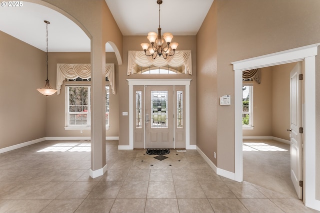 205 W Oriole Dr, Roseburg, OR 97471 - entrance foyer with light tile patterned floors, baseboards, arched walkways, a chandelier, and a towering ceiling