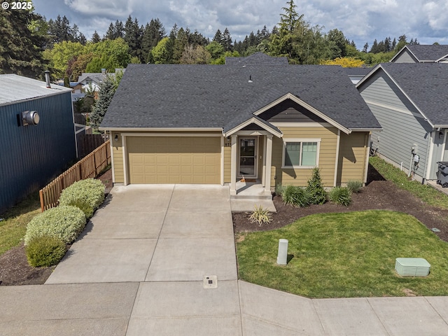 view of front of property with fence, a shingled roof, a front lawn, a garage, and driveway