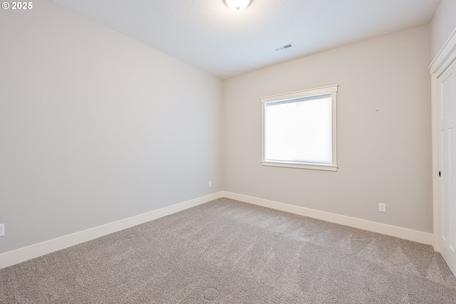 carpeted spare room with baseboards and visible vents