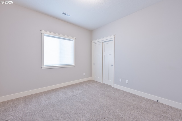 empty room with baseboards, carpet, and visible vents
