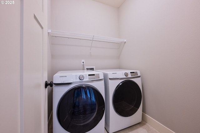 laundry area featuring baseboards, laundry area, and washer and clothes dryer