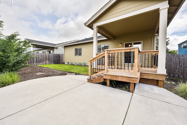 back of property featuring fence, a yard, a patio area, and a deck
