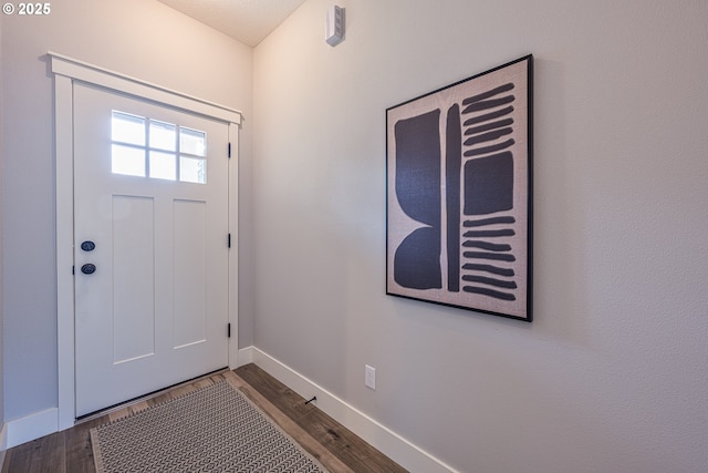 foyer entrance featuring baseboards and wood finished floors