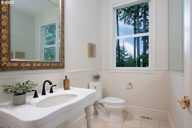 3830 NW 142nd Ter, Portland, OR 97229 - half bathroom with toilet, a sink, a wainscoted wall, ornamental molding, and baseboards