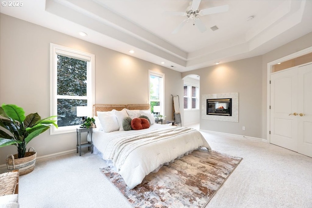 3830 NW 142nd Ter, Portland, OR 97229 - carpeted bedroom featuring a tray ceiling, recessed lighting, a multi sided fireplace, baseboards, and ceiling fan