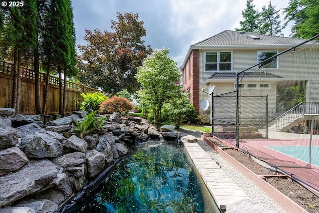 3830 NW 142nd Ter, Portland, OR 97229 - exterior space with a small pond and basketball hoop