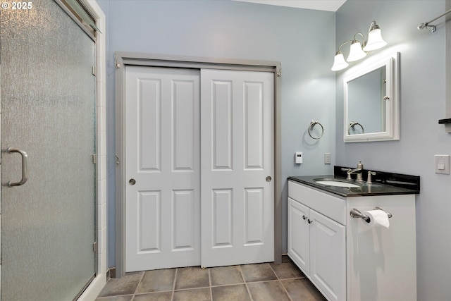 full bathroom featuring a stall shower, vanity, and tile patterned flooring