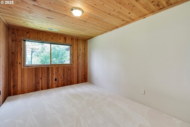 spare room with wood walls, wooden ceiling, and carpet floors