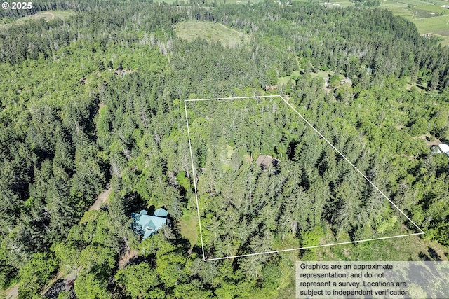 aerial view of property and surrounding area with a heavily wooded area and property parcel outlined