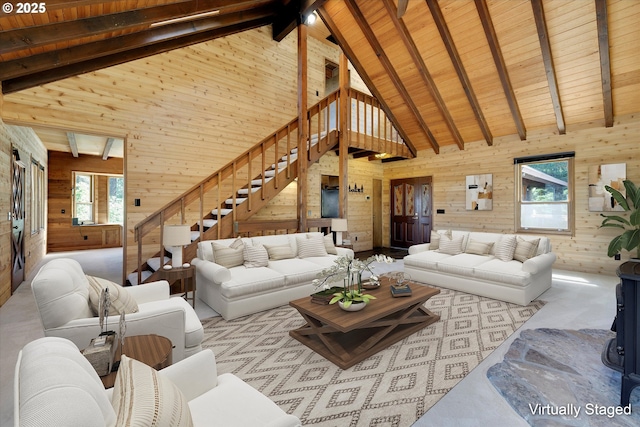 carpeted living area with wood walls, stairs, high vaulted ceiling, wooden ceiling, and beamed ceiling