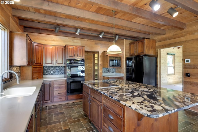 kitchen featuring black appliances, wood walls, a sink, wood ceiling, and beamed ceiling