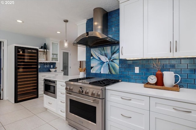 kitchen featuring light tile patterned floors, wall chimney exhaust hood, wine cooler, stainless steel appliances, and light countertops