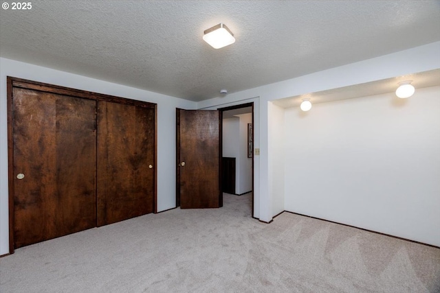 unfurnished bedroom featuring multiple closets, light carpet, and a textured ceiling