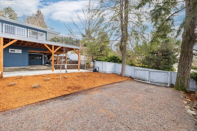 view of yard with driveway, a gate, and fence