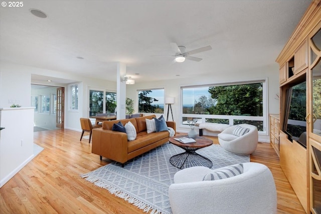 living room featuring ceiling fan and light wood finished floors