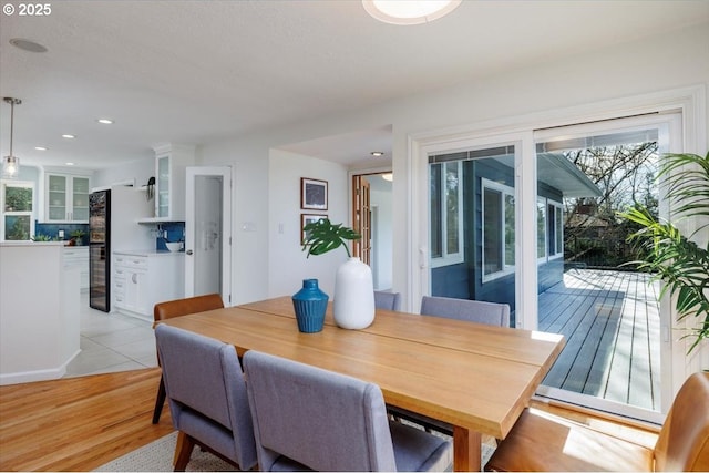 dining area with light wood finished floors and recessed lighting